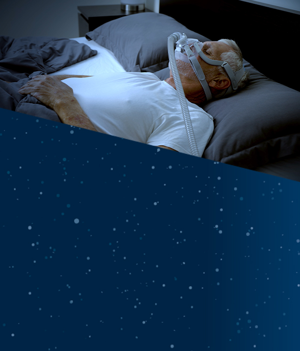 Man sleeping in bed, wearing a sleep apnea mask