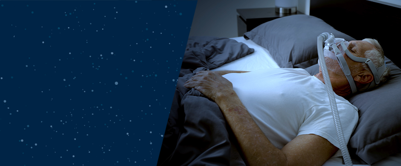 Man sleeping in bed with sleep apnea mask