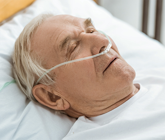 Older man sleeping with the assistance of a nasal cannula