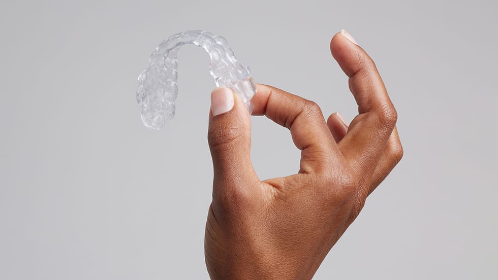 Hand holding oral appliance therapy device